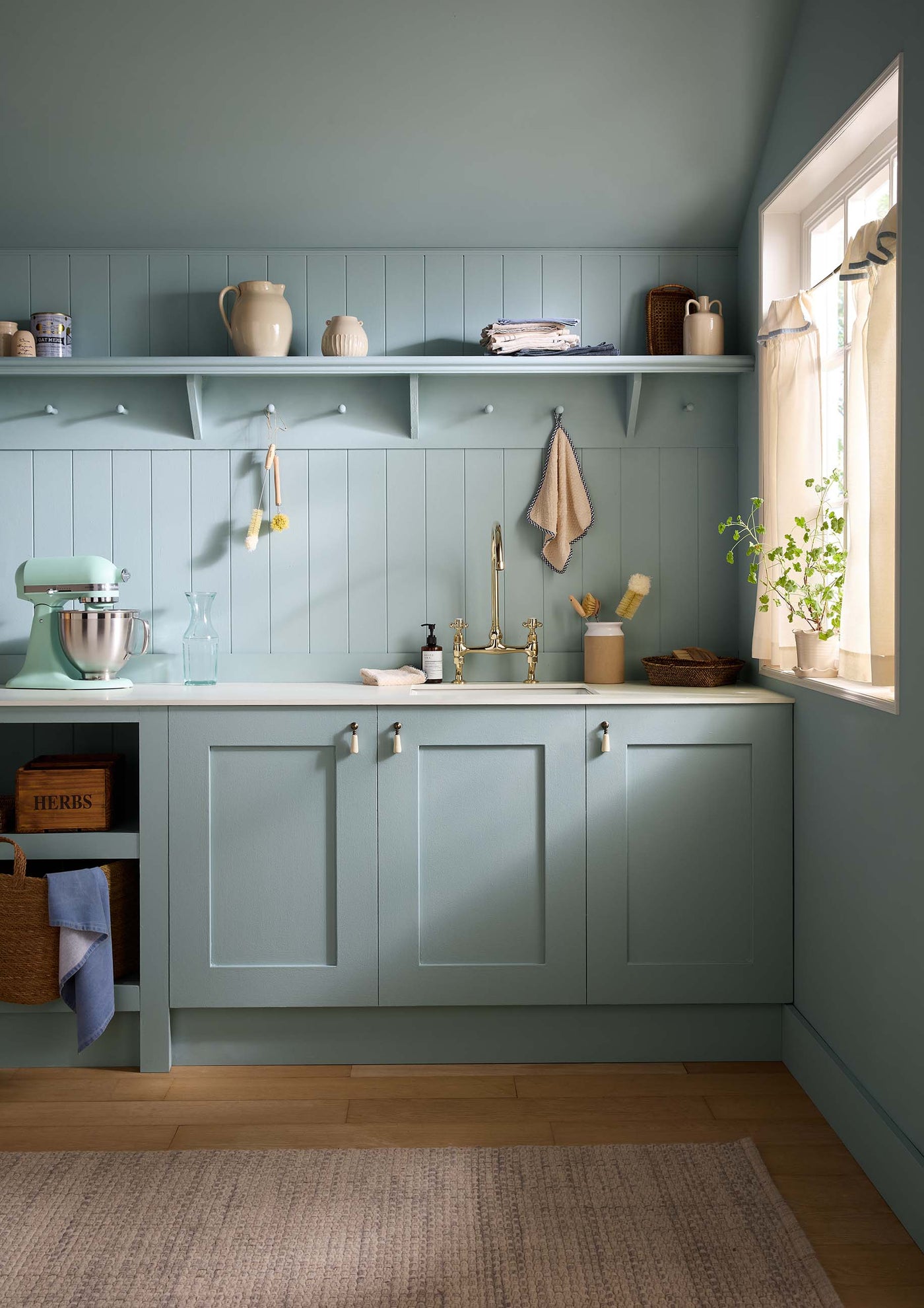 Modern kitchen with light blue cabinets and a window view