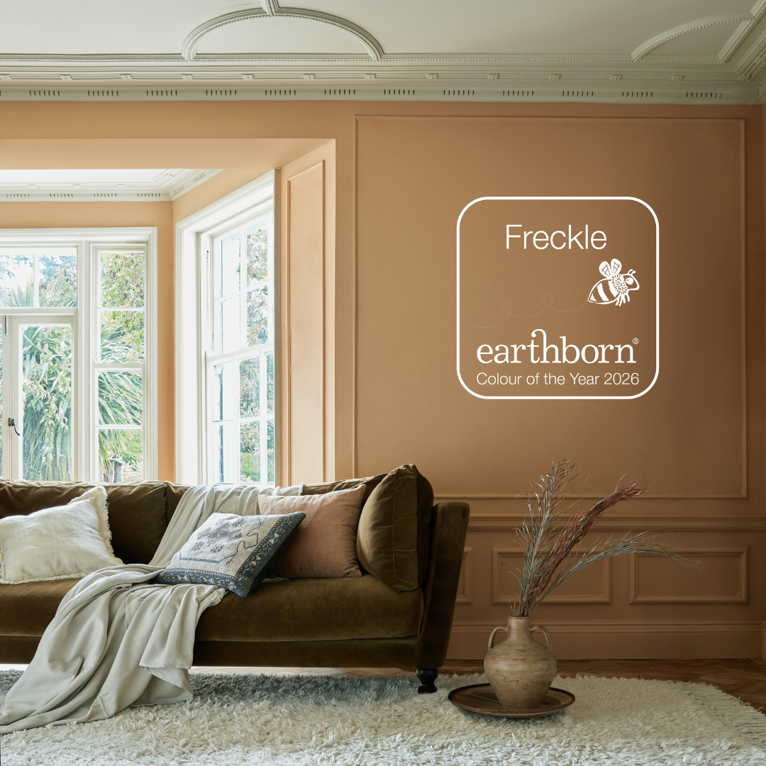 Colour of the Year 2026 Freckle painted on the wall in a living room with a couch.|||