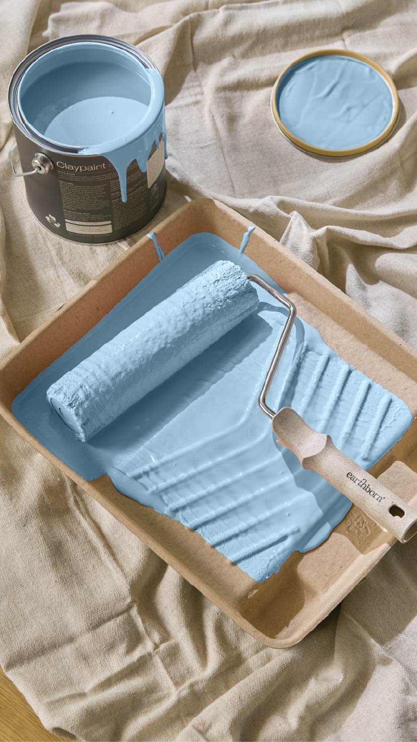 Paint roller in tray with blue paint
