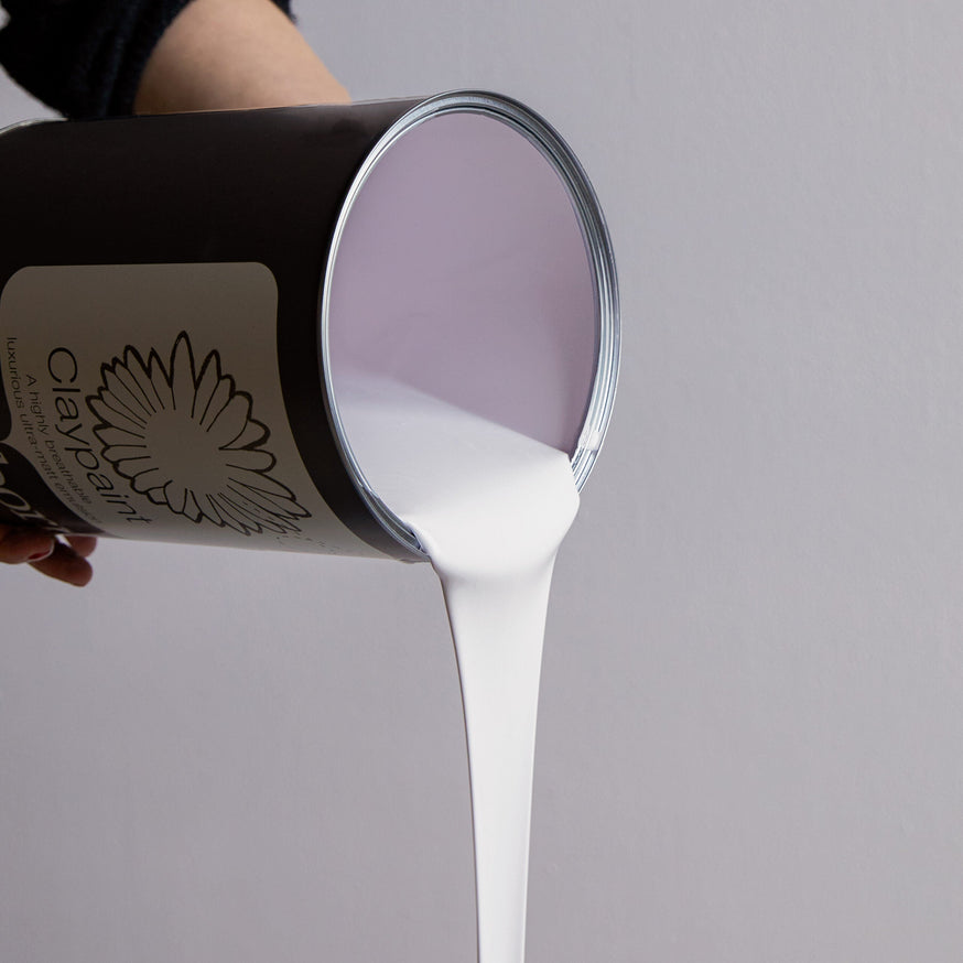 Paint tin tilted to the side with paint pouring out.