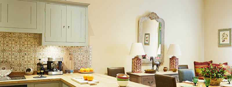 North facing rooms.|Colours for north facing rooms|Back to our roots banner.|Three neutral colour drops in a row.|Orange wall and table set next to a green panelled wall with a bed and side table.|Split image showing a grey wall with a cream couch and yel