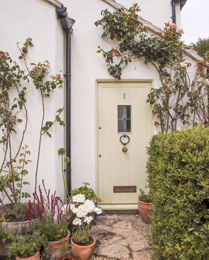 Little Stone Cottage painted in Buttermilk.|Emma and child in front of little stone cottage.|Little Stone Cottage front door.