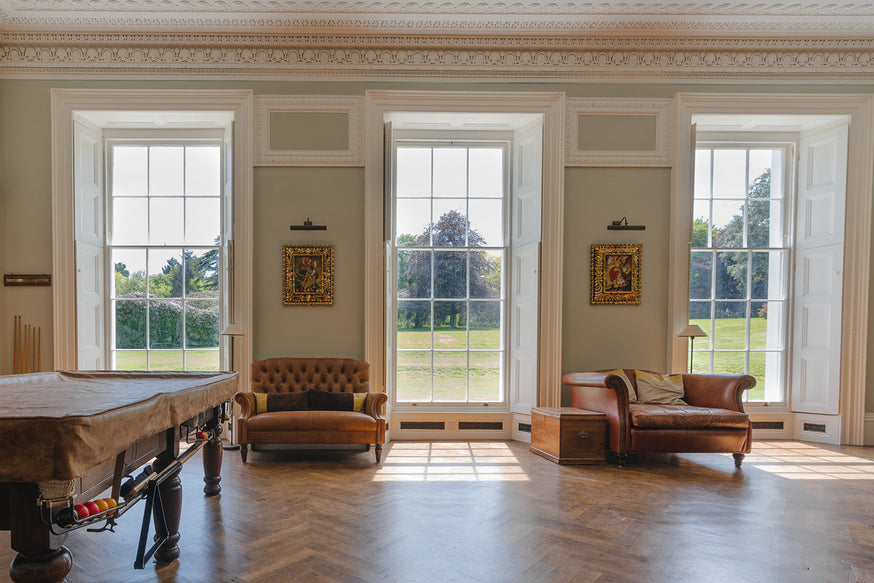 Moreton House Club Room after|Cats Cradle mood board.|A door way leading to a passage way with paint for listed buildings|A stair case with an old with a low hanging gold light and grey slate tiles. Paint for listed buildings
