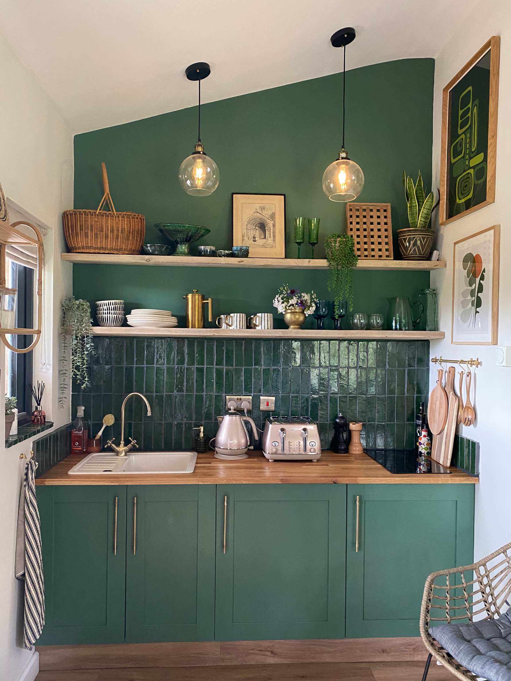Kitchen nook with the wall and cabinets painted green.|Kitchen transformation|An open dinning room looking into a minimal kitchen.|A close up of hands sanding a wooden draw in preparation.|Close up of hands painting a wooden draw using an Earthborn paint