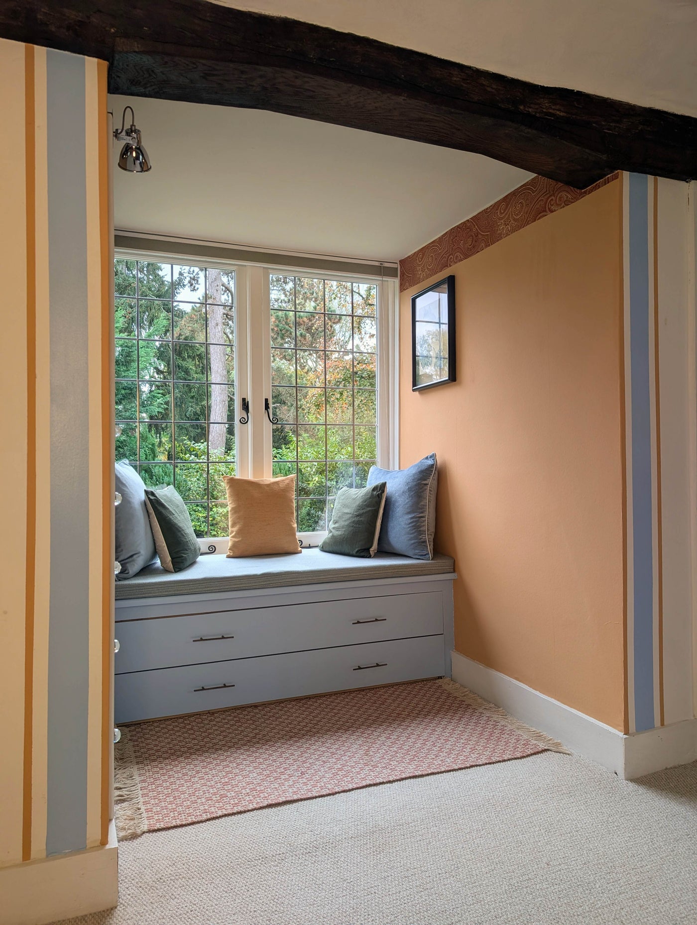 Nook with window seat, cushions, and a view of trees