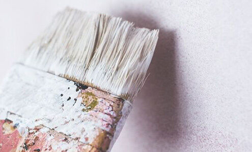 Paint brush painting a wall.