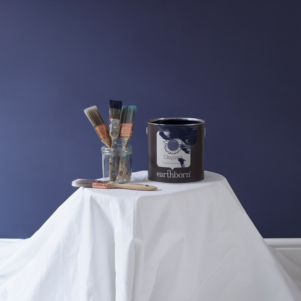 When it comes to painting a room don't forget the dust sheets! This lovely wall colour is Earthborn's Trumpet