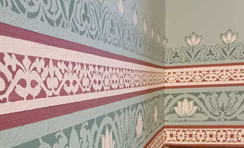 The corner of a wall with bold patterned edging and floral design.