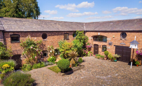 A beautiful barn conversion with a lovely spread of plants and flowers.