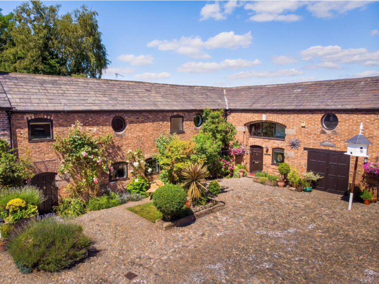 A beautiful barn conversion with a lovely spread of plants and flowers.