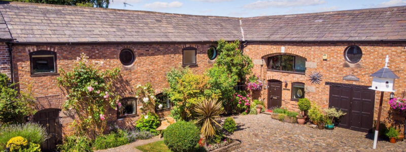 A beautiful barn conversion with a lovely spread of plants and flowers.