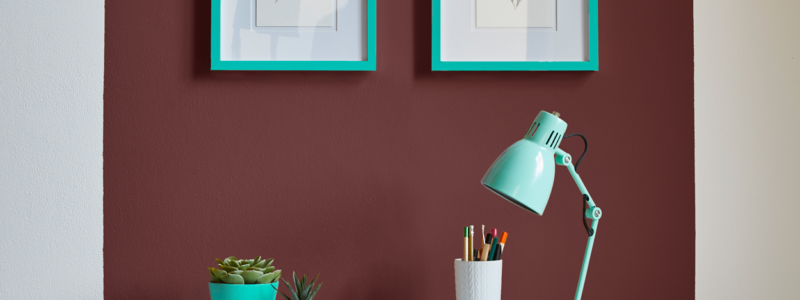 A small white desk against a colour blocked wall.