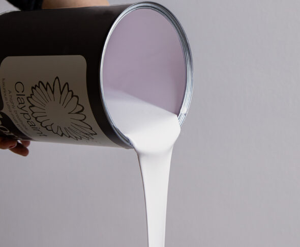 Paint tin tilted to the side with paint pouring out.