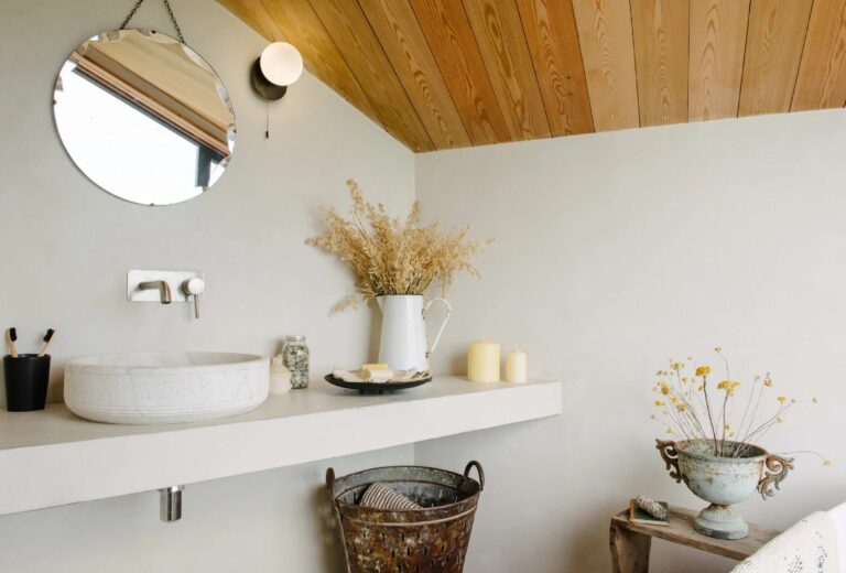 Bathroom sink in a white room with a wooden ceiling.