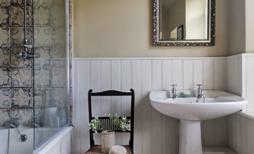 Neutral and white bathroom with blue patterned tiles.