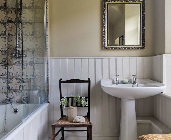 Neutral and white bathroom with blue patterned tiles.