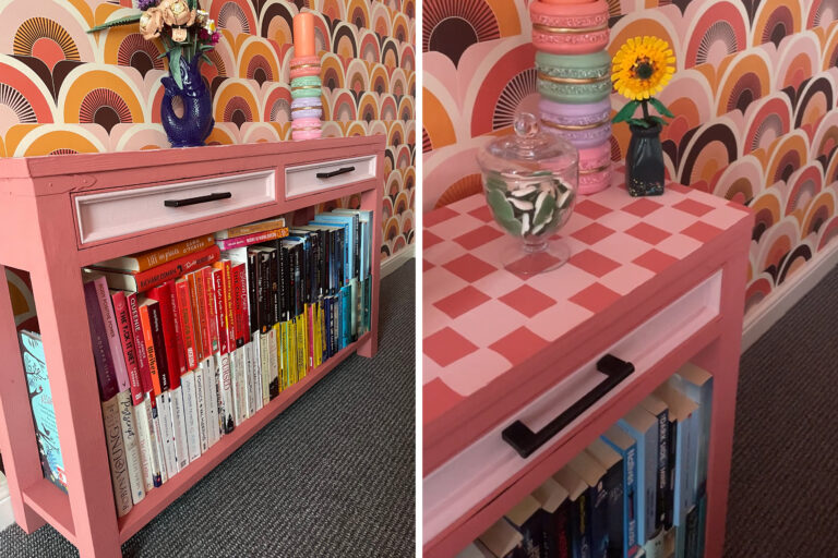 Brightly decorated wall and table with books stacked underneath, a vase and candle on top of the table.