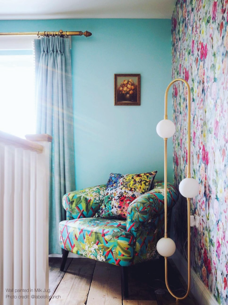 Corner of an upstairs landing with a brightly patterned armchair and cushion.