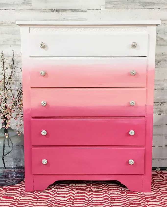 Chest of drawers painted in a bright ombre of pink to white.