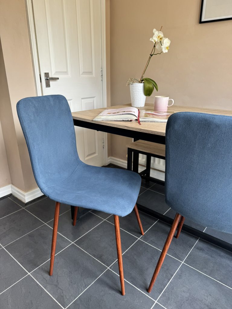 Two fabric chairs by a kitchen table.